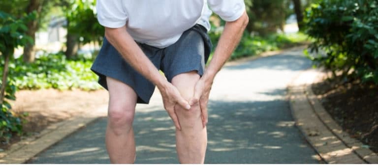 Homem interrompe sua caminhada após sentir dor no joelho